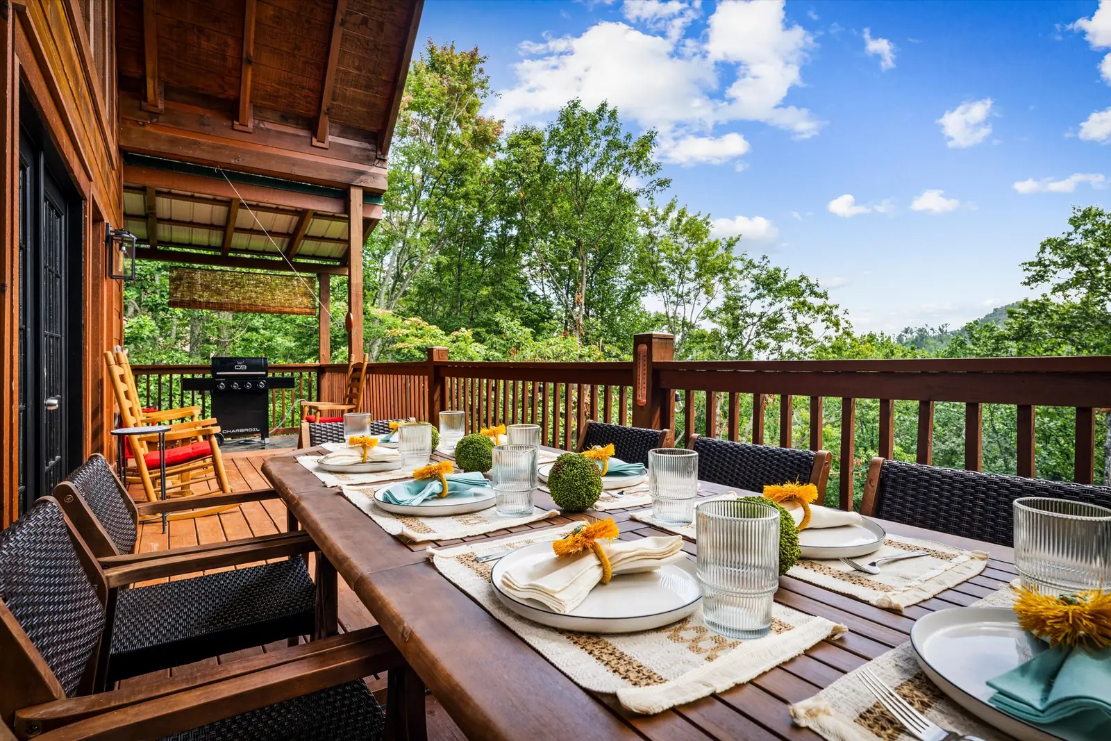 Outdoor dining table set for eight on the covered deck at Acorn Ridge
