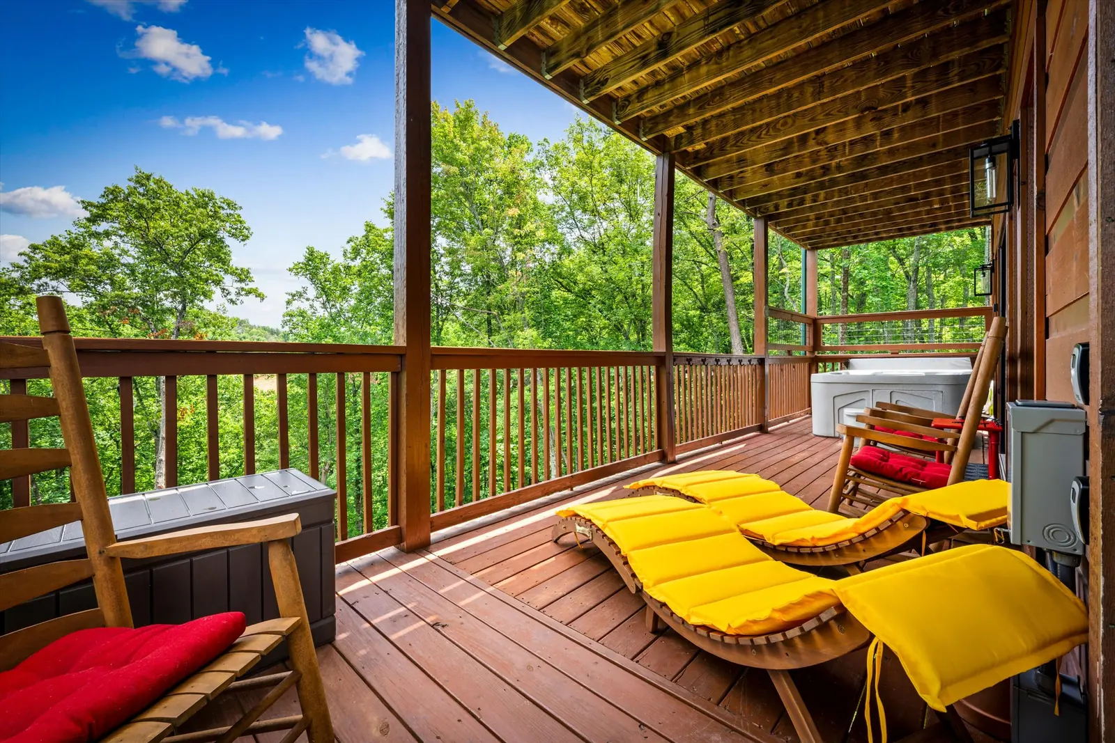 Yellow-cushioned loungers and rocking chairs on the lower covered deck