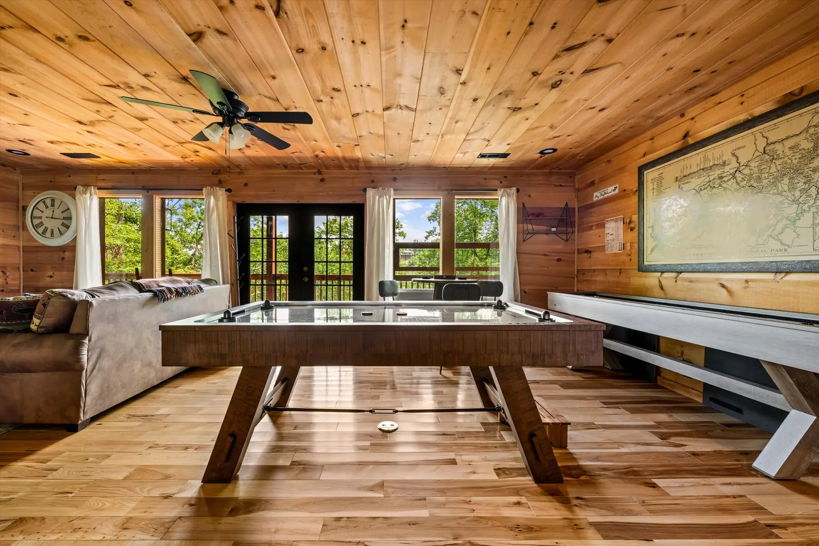 Lower-level game room with an air hockey table and a shuffleboard table