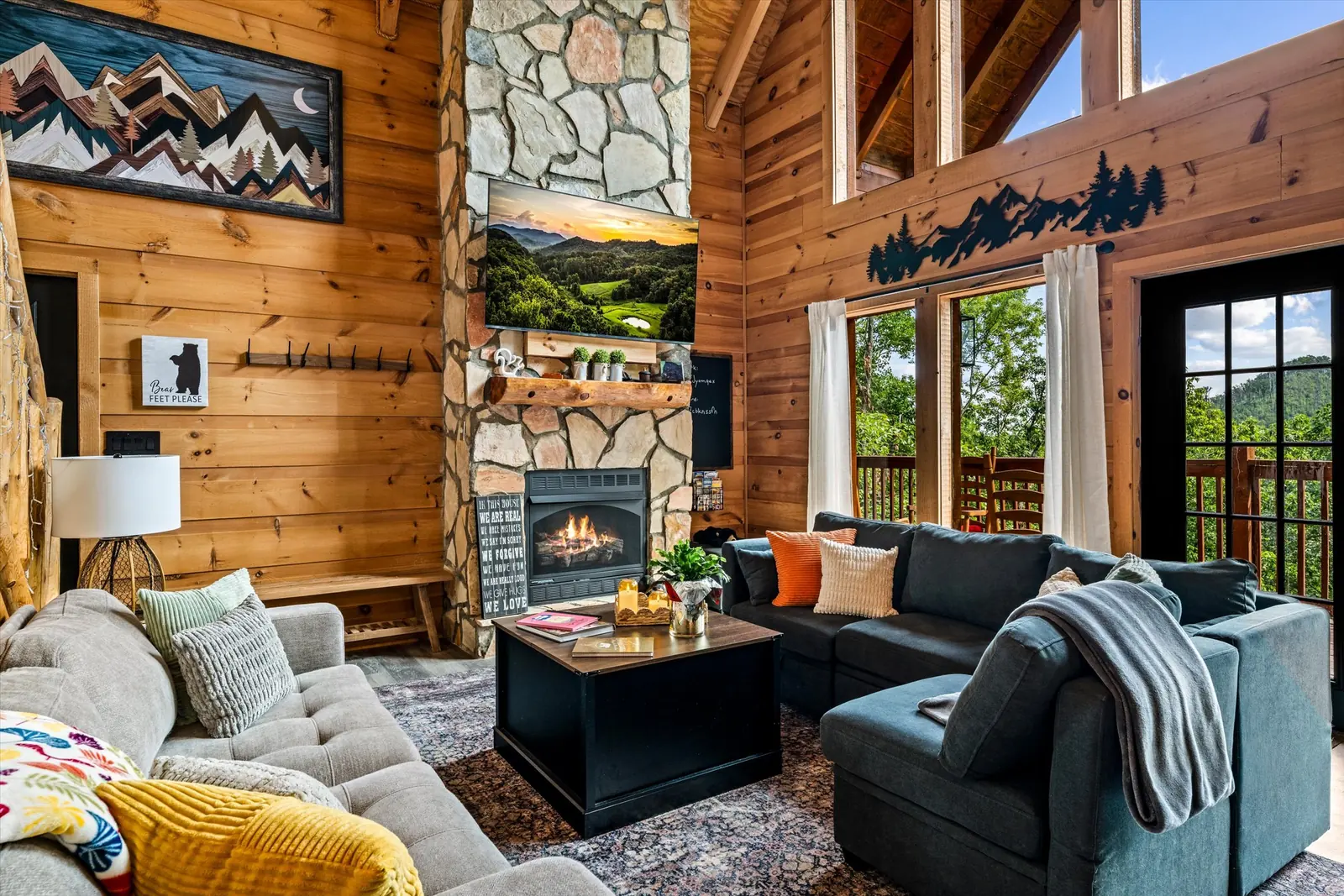 Great room with stone fireplace, sectional sofa and vaulted wood ceiling