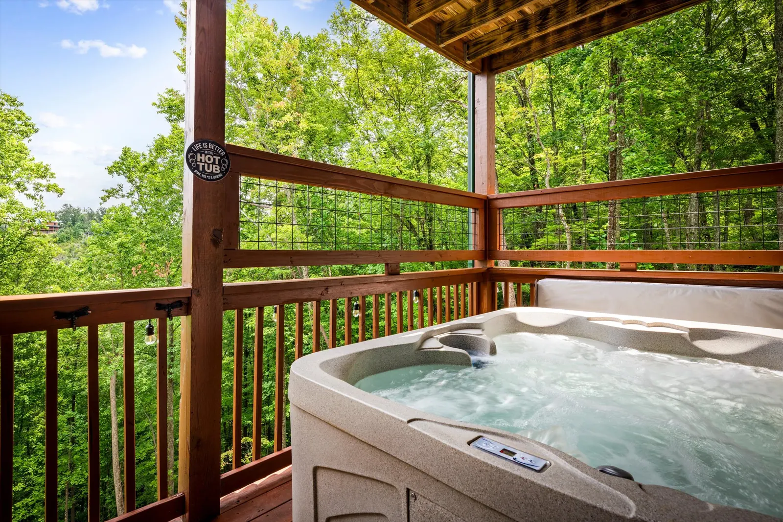 Hot tub on a covered deck at Acorn Ridge surrounded by forest