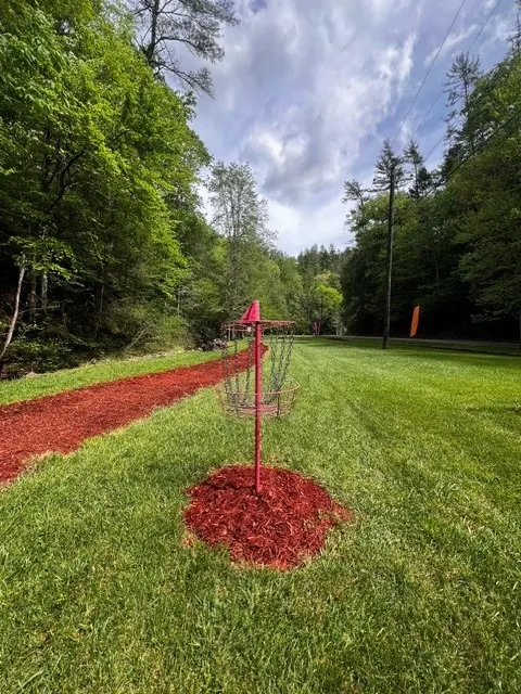 A disc golf basket on a manicured fairway in the Shagbark community park