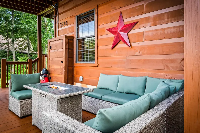 Outdoor sectional around a gas fire table beside the cabin entry