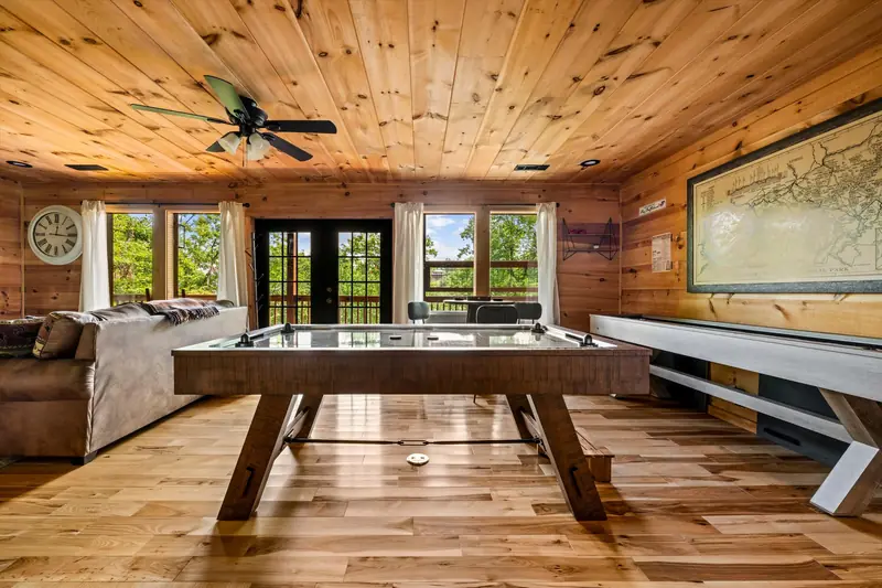 Lower-level game room with an air hockey table and a shuffleboard table